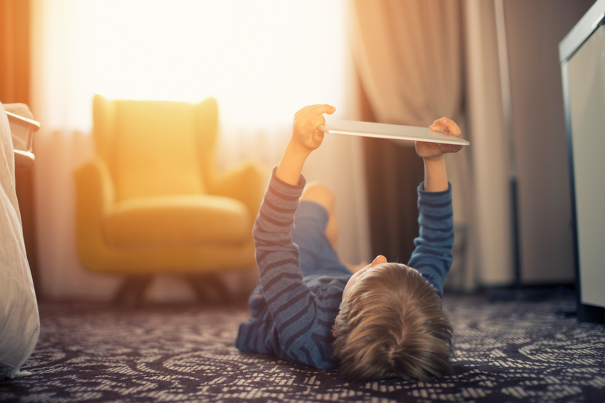 Little boy playing with digital tablet on the floor