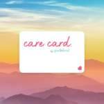 a Give InKind Care Card floats before the backdrop of a rainbow mountain sunset.
