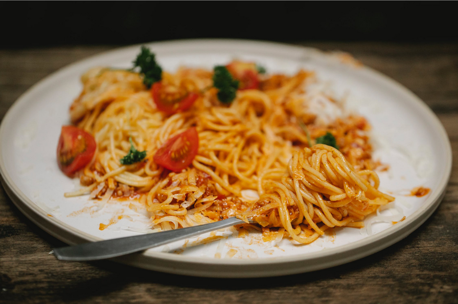 plate of pasta being eaten mid-meal. a simple pasta dish makes for great meal train recipe ideas