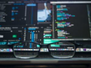 glasses in front of a computer screen. the screen is blurry, but what you can see through the lenses of the glasses is clear