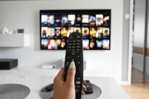 hand holding a remote control that browses a streaming video platform