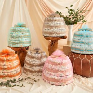 Diapers arranged in cake shapes and wrapped with multicolored tule fabric. Diapers and wipes are great gifts if you're looking for meal train ideas for new parents.