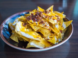 dish of nachos with cheese, sour cream, and meat on top. one of our favorite meal train food ideas