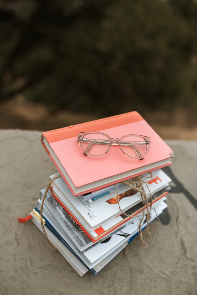 stack of books with a pair of glasses sitting on top