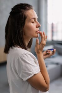 Person applying lip balm to their lip with their finger